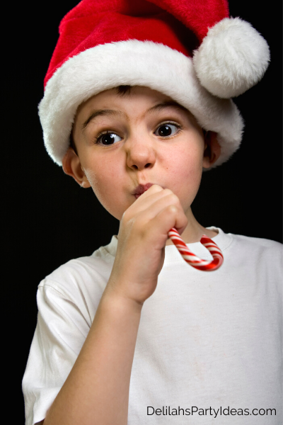 Young child with Santa hat on with Candy Cane in his mouth