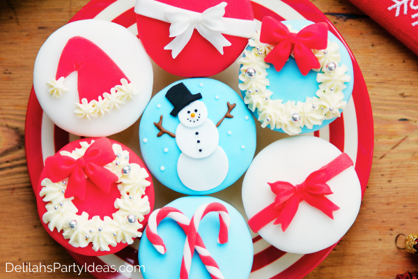 Red and white plate with 7 Christmas decorated cupcakes, made with fondant.