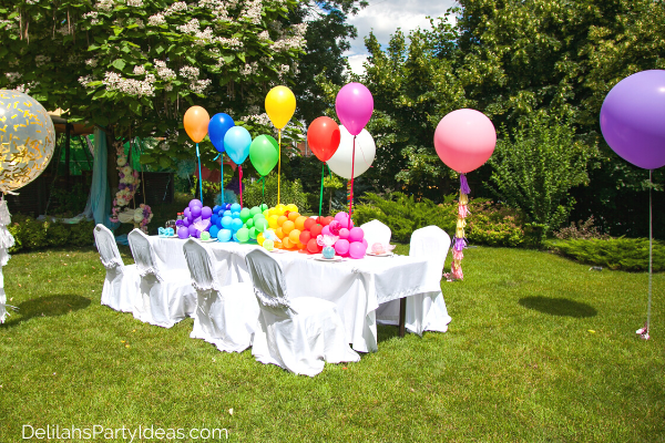 Garden Party Table Setting white table cloth and colorful small balloons on table