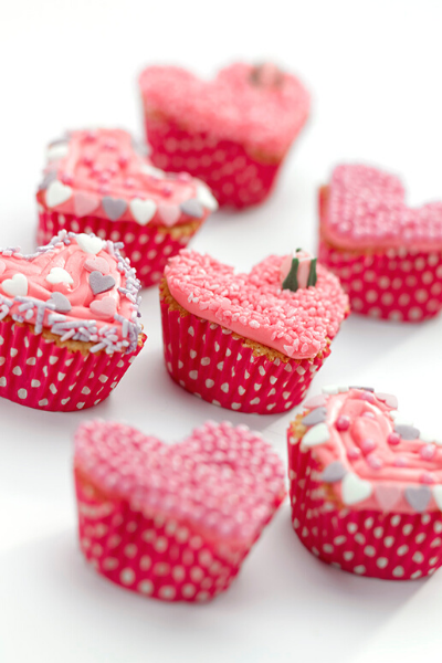 7 Pink heart shaped cupcakes with pink icing and sprinkles