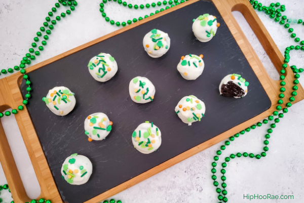 Board with St Patrick's Day Oreo Truffles on it with green beads as decoration