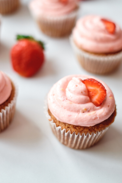  Strawberry Churro Cupcakes with fresh strawberry on top of icing