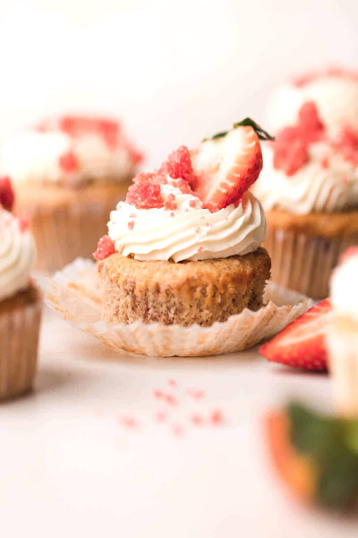 Strawberry Crunch Cupcake with cupcake liner puller down. Fresh strawberry on the top