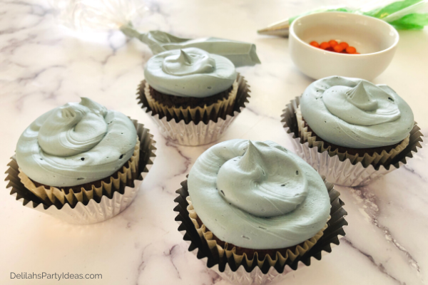 Icing the chocolate cupcakes with gray frosting