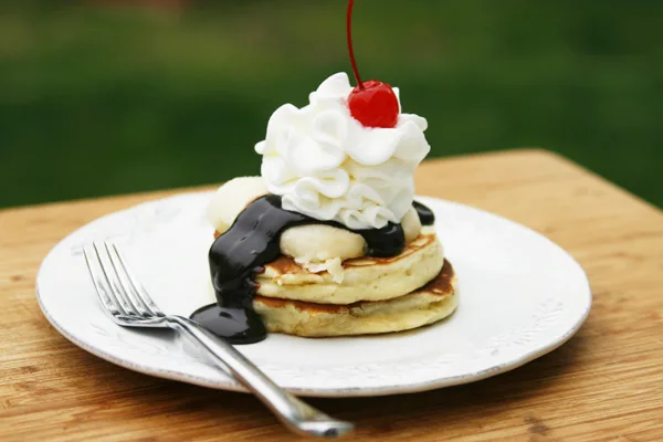 Banana Split Pancakes with chocolate sauce and a cherry on top