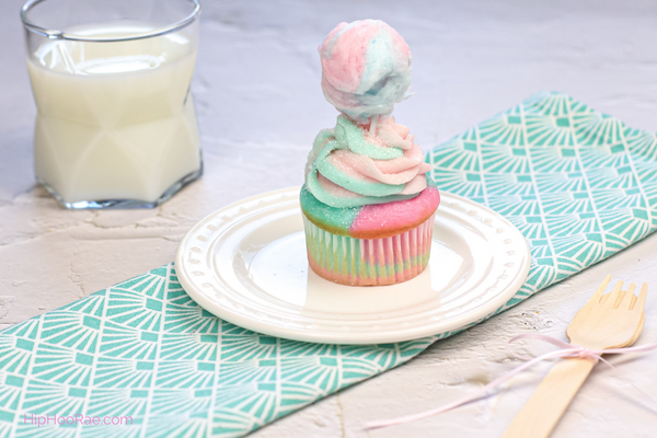 Pastel colored cupcakes with cotton candy on the top of the icing