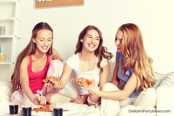 3 Teens having a sleepover eating pizza