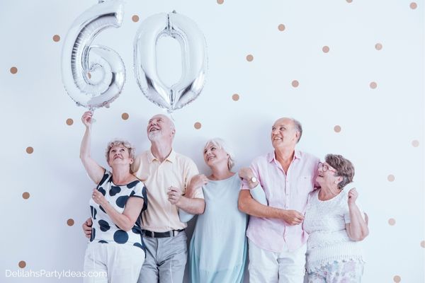 60th Birthday friends holding 60th Balloon