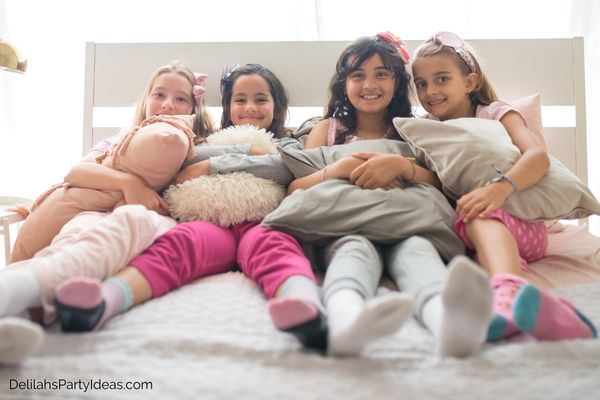 4 tweens on a bed in pj's at a Pajama Party