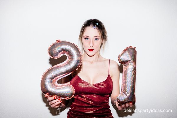 Girl holding 21st balloons