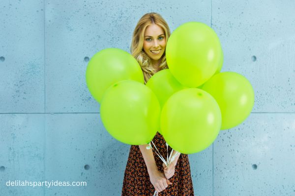 Woman with bunch of green balloons