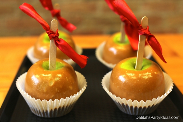 caramel apples in cupcake liners with ribbon on the sticks