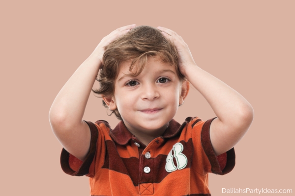 Little boy touching his head