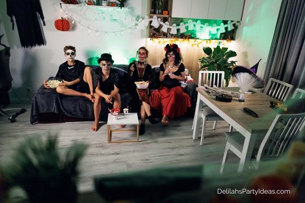 family in halloween costumes watching a movie