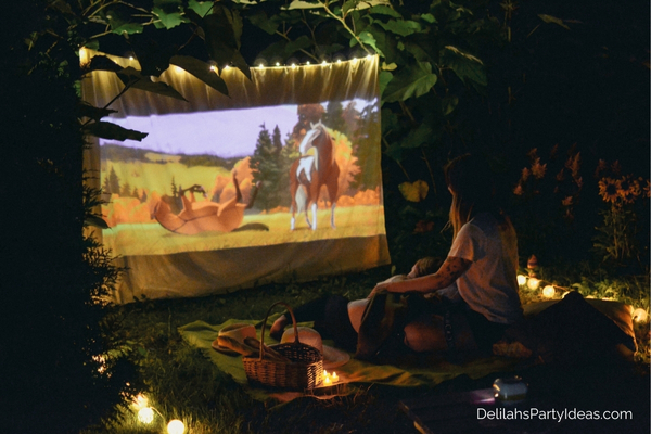 couple watching a movie on the projector outdoors