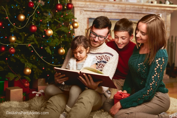 family reading a book by the Christmas tree