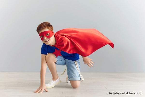 boy wearing a cape and mask superman costume
