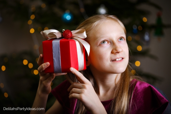 Girl trying to hear what's inside a Christmas gift