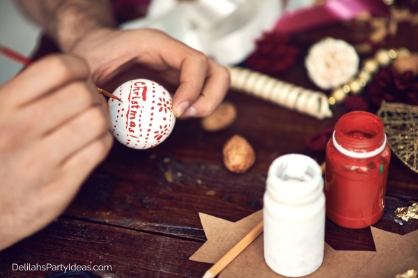 Someone painting a Christmas ornament