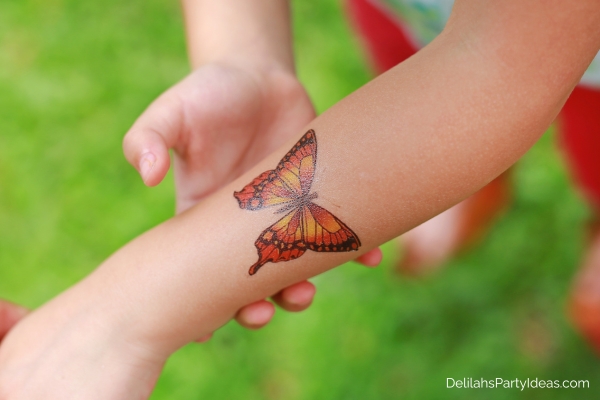 butterfly sticker tattoo on someone's arm