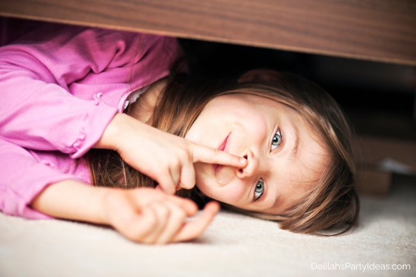 little girl hiding under a bed