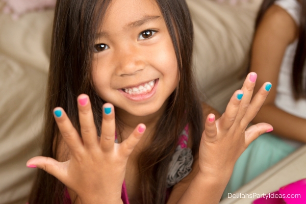 little girl holding up her hands with nail polish