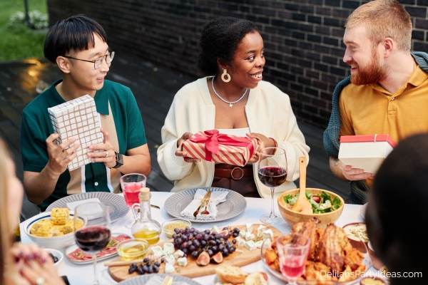 friends sharing gifts at lunch party outdoors