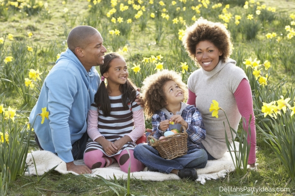 Family sitting on field of spring daffodils