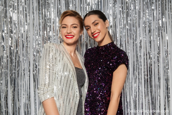 2 women in sparkly clothes on sparkly background