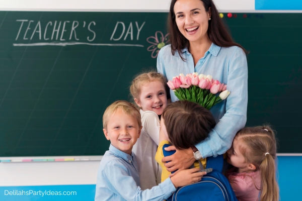 Female teacher holding bouquet of flowers given by her students on Teachers Day