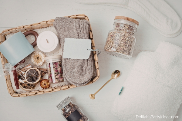 gift basket containing mug, tea leaves, socks, candle