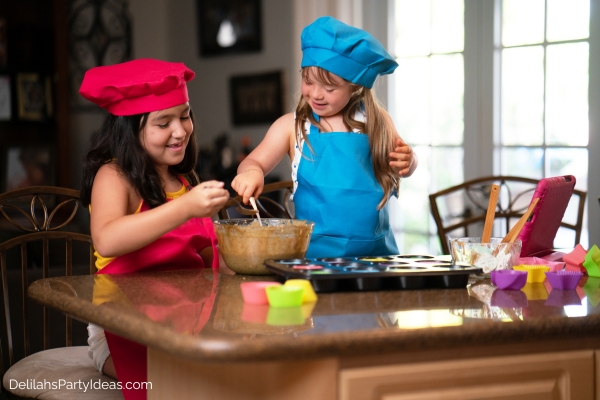 2 girls wearing aprons while baking 