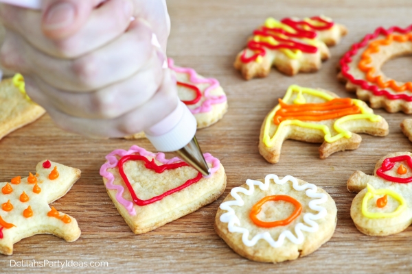 hand piping frosting onto a cookie