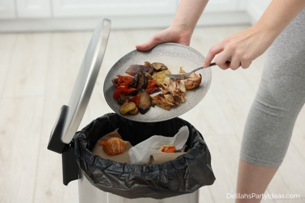 woman throwing leftovers in trash can