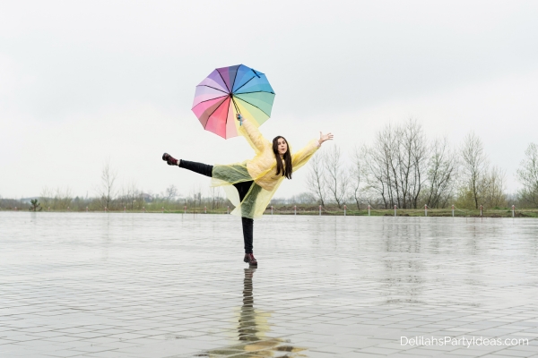 Woman holding an umbrella dancing in the rain