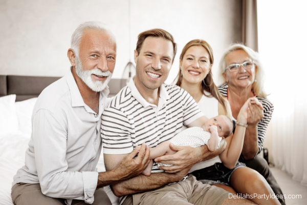 Father holding his baby, with his father, wife, mother.