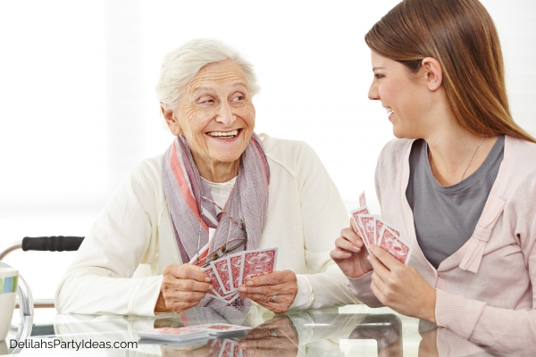 elderly woman playing card game with caregiver