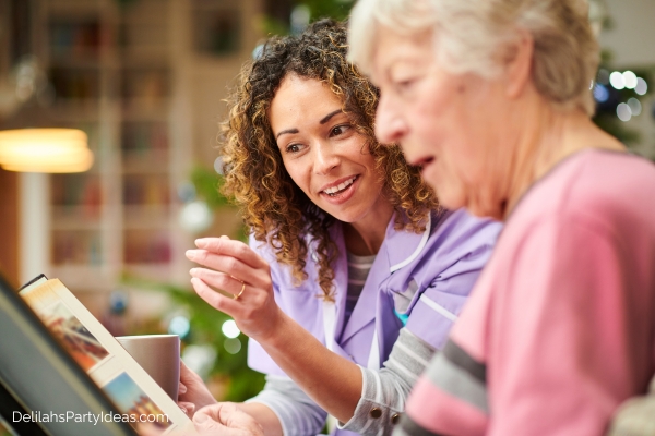 senior woman looking at photos with caregiver
