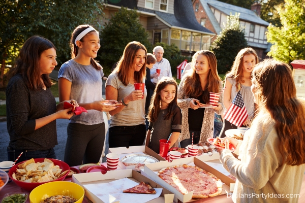 people enjoying food from potluck table at a block party