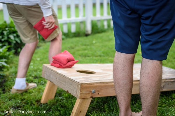 2 men playing cornhole game