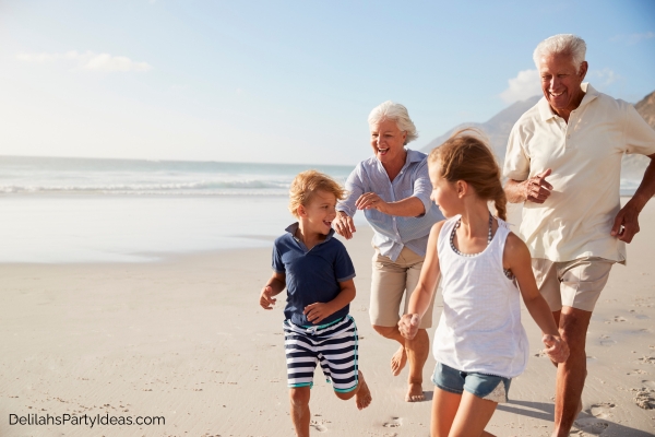 grandparents with their grandkids running at the beach