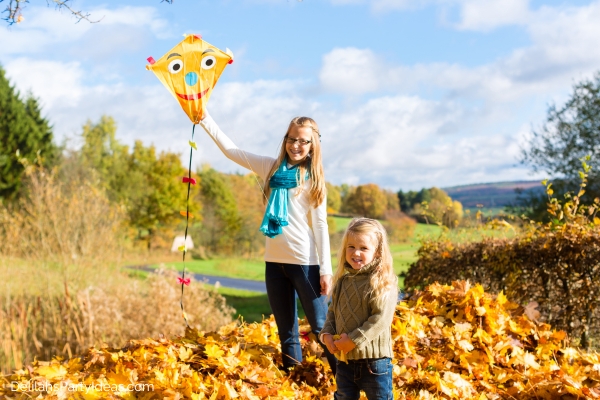 2 girls flying a kite in fall season